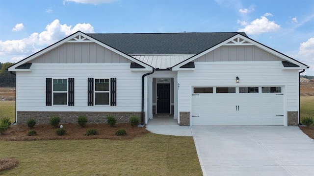 view of front of property with brick siding, an attached garage, a standing seam roof, driveway, and a front lawn