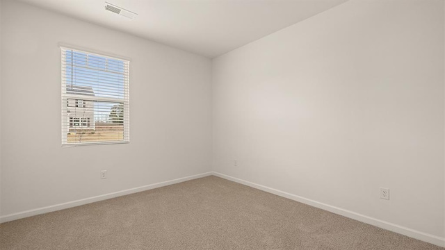 spare room with carpet, visible vents, and baseboards