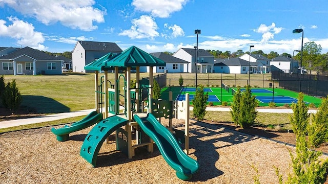 community jungle gym with a residential view, fence, and a yard