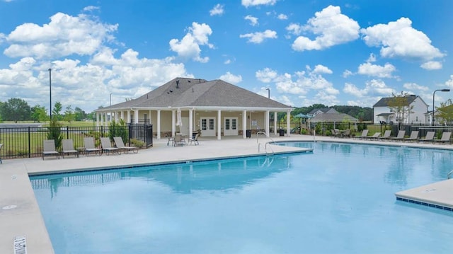 community pool with a patio and fence