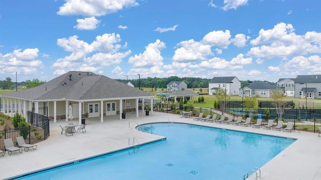 pool with french doors, a patio area, and fence