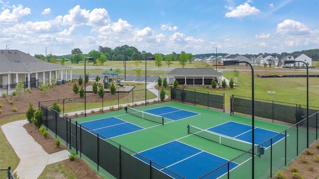 view of sport court with a residential view, fence, and a lawn