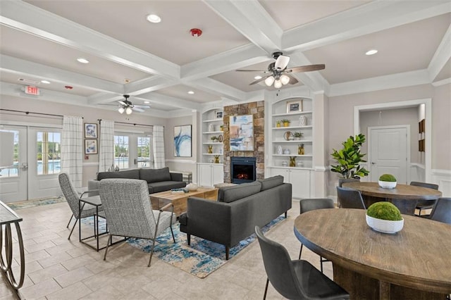 living area with a stone fireplace, french doors, beamed ceiling, and built in features