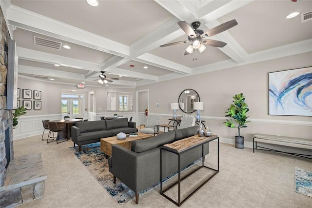 living room with visible vents, coffered ceiling, wainscoting, a decorative wall, and beam ceiling