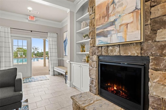 interior space with built in features, crown molding, a fireplace, light tile patterned floors, and visible vents