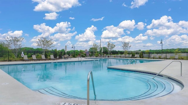 community pool with fence and a patio