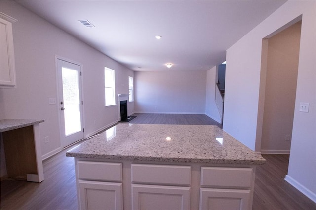 530 River Run Dr, Dallas, GA 30132 - kitchen featuring dark wood-type flooring, a fireplace, a center island, light stone counters, and recessed lighting