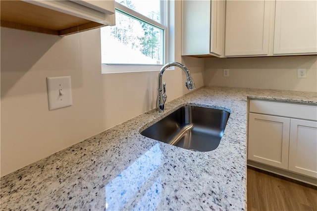 530 River Run Dr, Dallas, GA 30132 - kitchen view of a sink, light stone counters, and white cabinetry