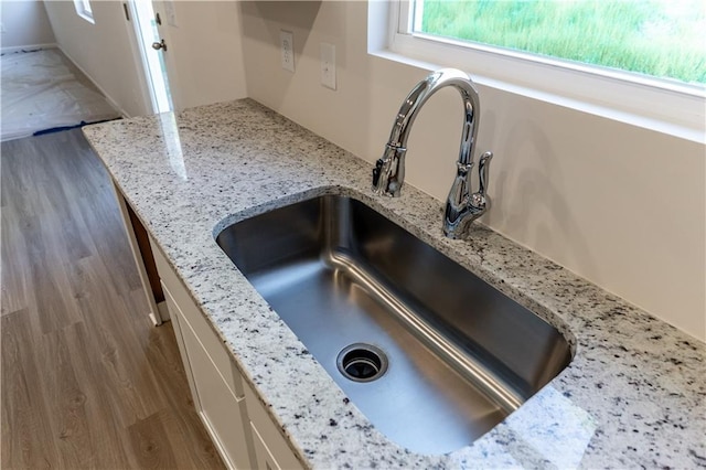530 River Run Dr, Dallas, GA 30132 - kitchen view of a sink, wood finished floors, white cabinets, and light stone countertops