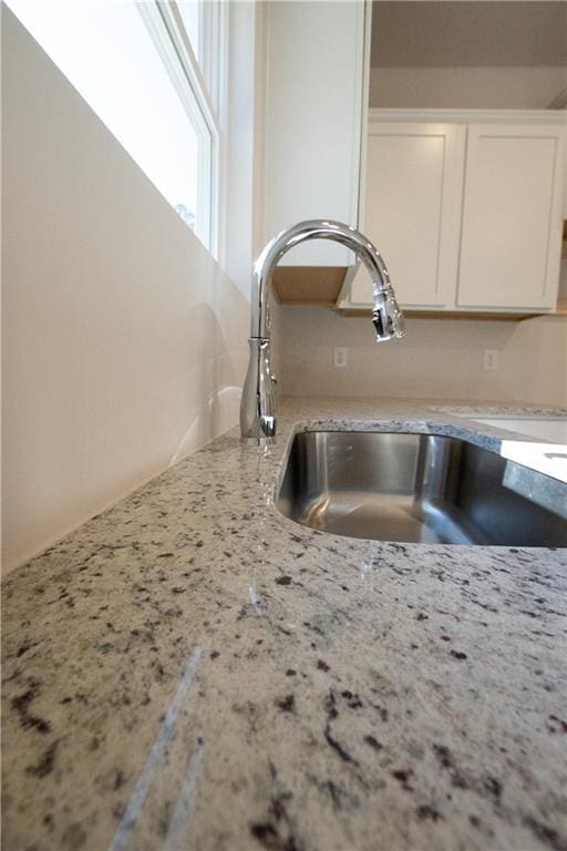530 River Run Dr, Dallas, GA 30132 - kitchen view of a sink, white cabinetry, and light stone countertops