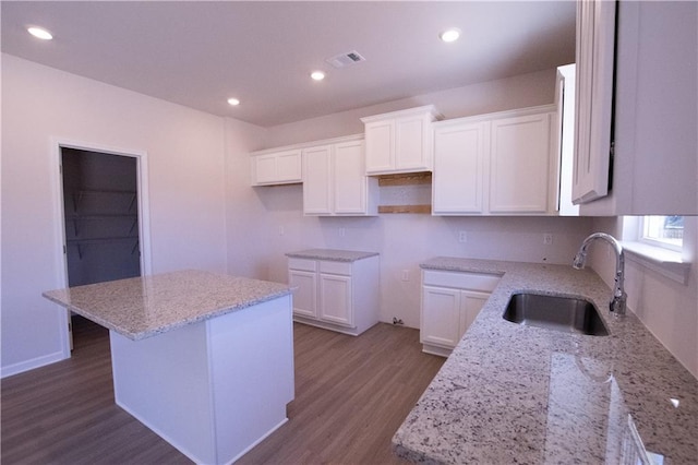 530 River Run Dr, Dallas, GA 30132 - kitchen with a sink, wood finished floors, light stone countertops, white cabinetry, and recessed lighting