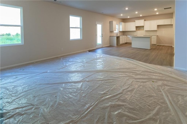 530 River Run Dr, Dallas, GA 30132 - unfurnished living room featuring baseboards, recessed lighting, light wood-style flooring, and a sink