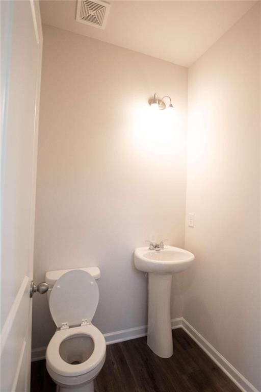 bathroom with toilet and hardwood / wood-style floors