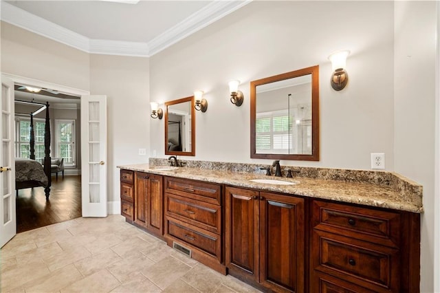 full bathroom with double vanity, ornamental molding, french doors, and a sink