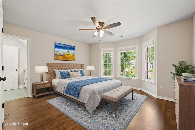 bedroom with visible vents, baseboards, dark wood-style floors, and a ceiling fan