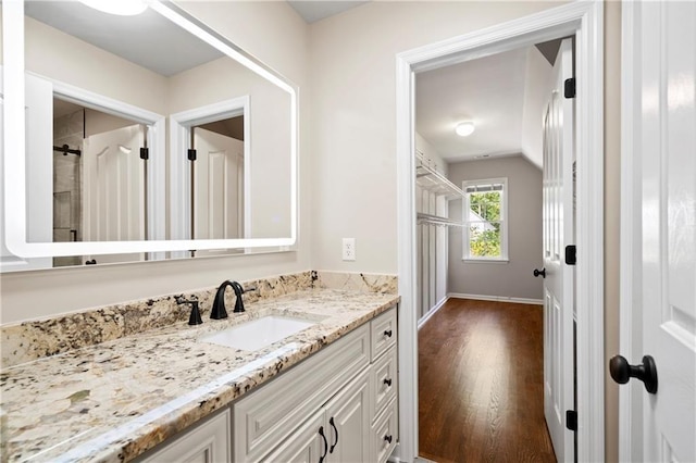 bathroom featuring lofted ceiling, wood finished floors, and vanity