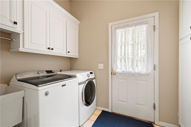 laundry room with washer and dryer, a sink, cabinet space, light tile patterned flooring, and baseboards