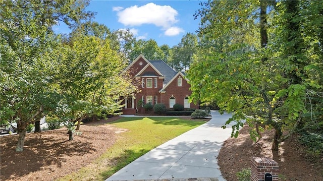 view of front of property featuring concrete driveway and a front lawn