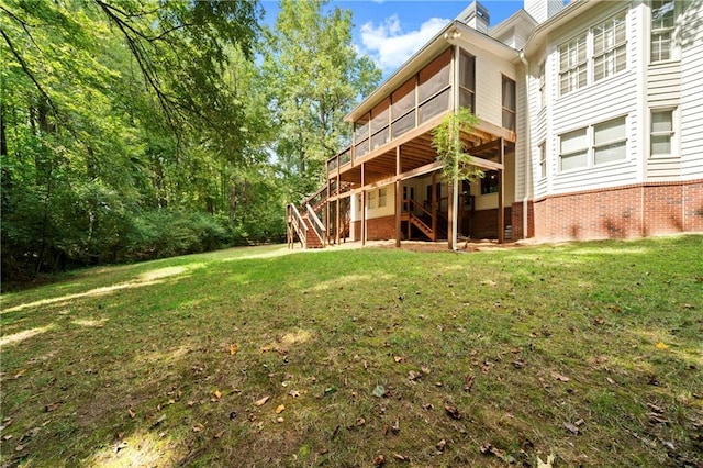 back of property with stairs, a lawn, and a chimney