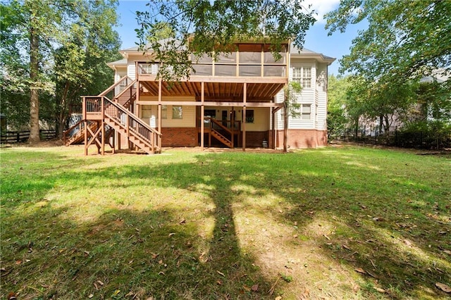 rear view of property featuring a yard, fence, stairs, and a sunroom