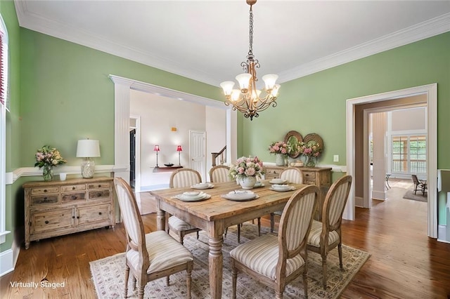 dining space with a notable chandelier, dark wood-type flooring, and ornamental molding