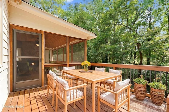 deck with outdoor dining area and a sunroom