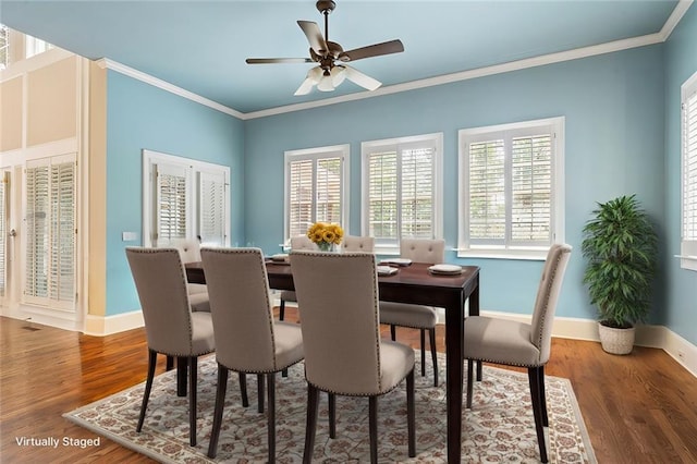 dining area with a ceiling fan, crown molding, baseboards, and wood finished floors