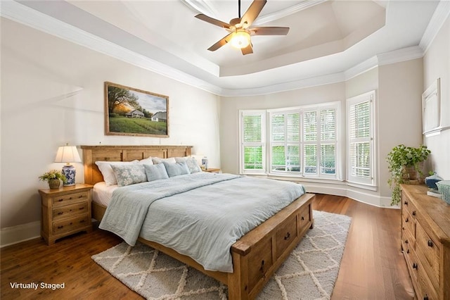 bedroom with a tray ceiling, baseboards, and dark wood-type flooring