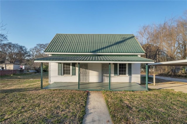 farmhouse-style home featuring a front lawn and a carport