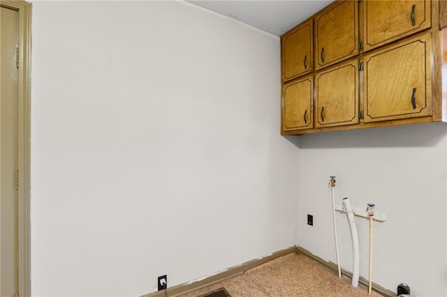 clothes washing area with cabinets and washer hookup