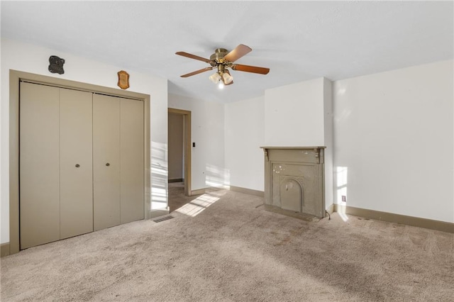 unfurnished living room featuring light colored carpet and ceiling fan