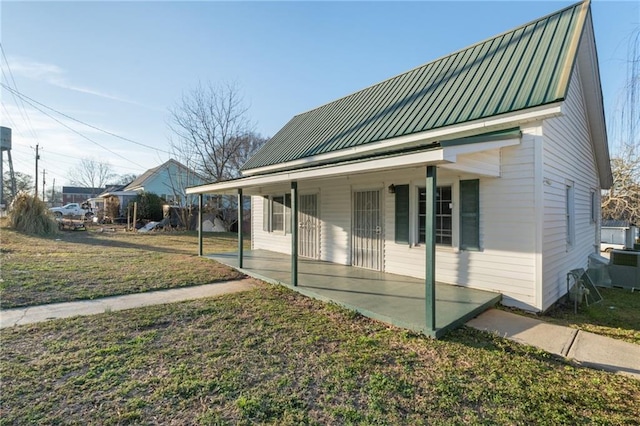 view of side of home with a yard and a porch