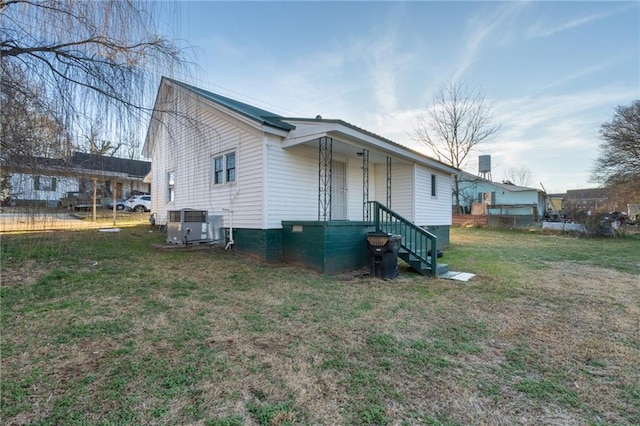 exterior space featuring cooling unit and a lawn