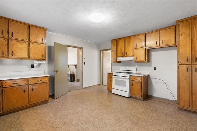 kitchen featuring white range with gas cooktop and a textured ceiling