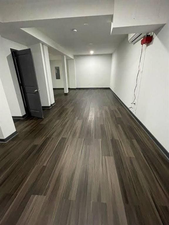 finished below grade area with baseboards and dark wood-type flooring