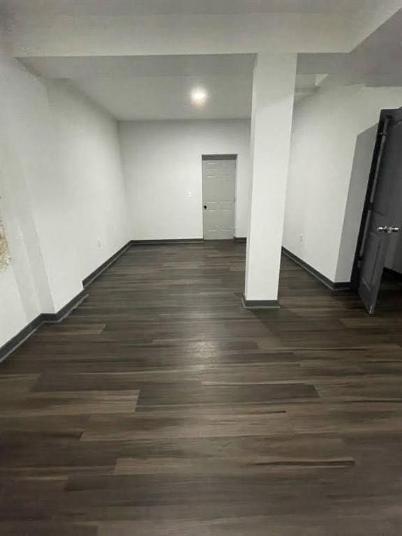 below grade area with baseboards and dark wood-type flooring