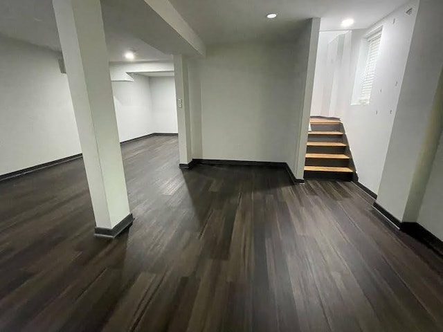 basement with baseboards, wood finished floors, recessed lighting, and stairs