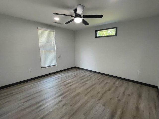 spare room with ceiling fan, baseboards, light wood-style floors, and visible vents