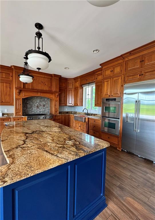 311 Langston Rd SE, Calhoun, GA 30701 - kitchen with appliances with stainless steel finishes, a sink, light stone counters, brown cabinetry, and recessed lighting