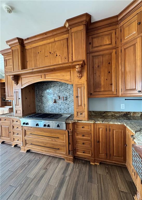 311 Langston Rd SE, Calhoun, GA 30701 - kitchen with dark wood-type flooring, stainless steel gas cooktop, brown cabinets, and stone counters