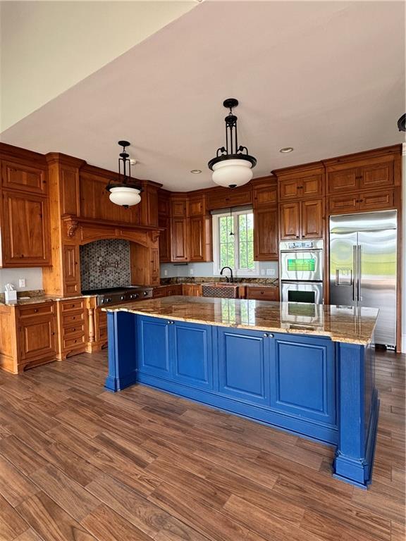 311 Langston Rd SE, Calhoun, GA 30701 - kitchen featuring stainless steel appliances, a spacious island, dark wood-type flooring, a sink, and pendant lighting