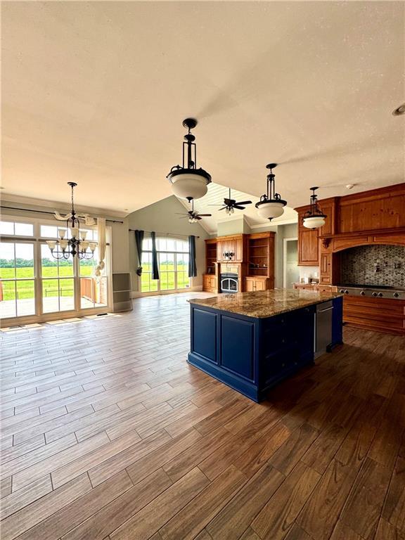 311 Langston Rd SE, Calhoun, GA 30701 - kitchen with dark wood-style flooring, open floor plan, a ceiling fan, a kitchen island, and a chandelier