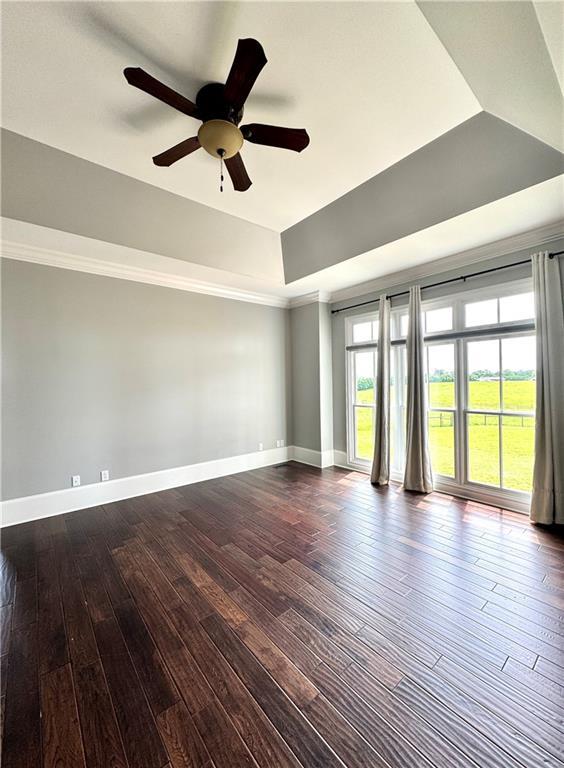 311 Langston Rd SE, Calhoun, GA 30701 - unfurnished room with dark wood-style flooring, ceiling fan, baseboards, and a tray ceiling