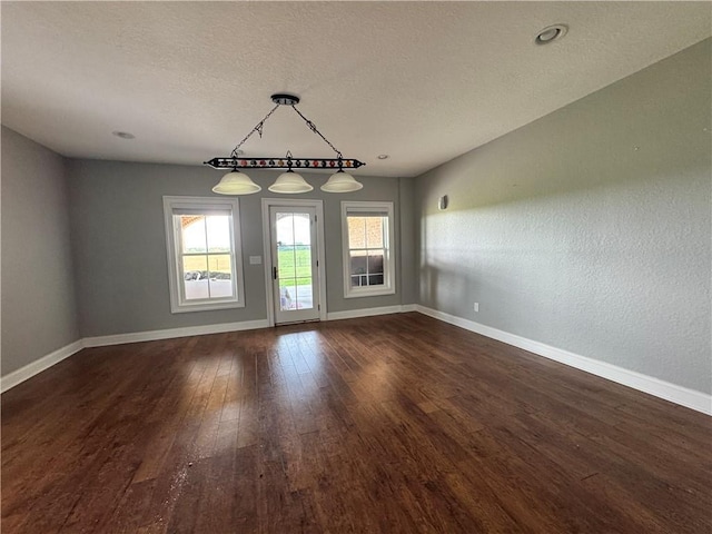 311 Langston Rd SE, Calhoun, GA 30701 - unfurnished dining area featuring baseboards, dark wood-style flooring, and a textured ceiling