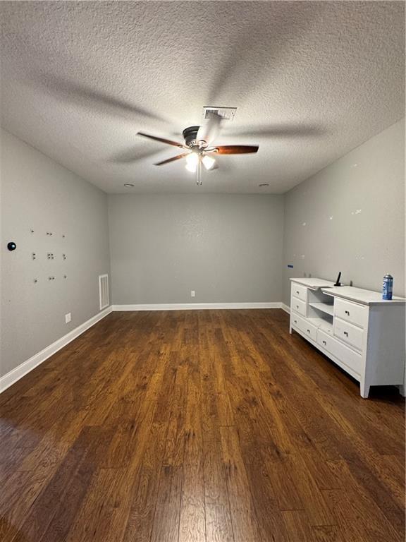 311 Langston Rd SE, Calhoun, GA 30701 - empty room with a ceiling fan, dark wood finished floors, a textured ceiling, and baseboards