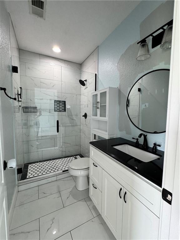 311 Langston Rd SE, Calhoun, GA 30701 - bathroom featuring marble finish floors, a stall shower, toilet, vanity, and recessed lighting