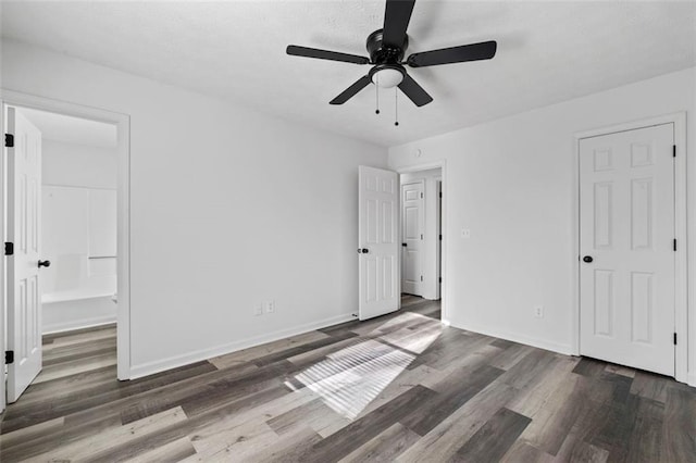 2571 Hamill Dr, Buford, GA 30519 - unfurnished bedroom with dark wood-style floors, baseboards, ensuite bathroom, and ceiling fan