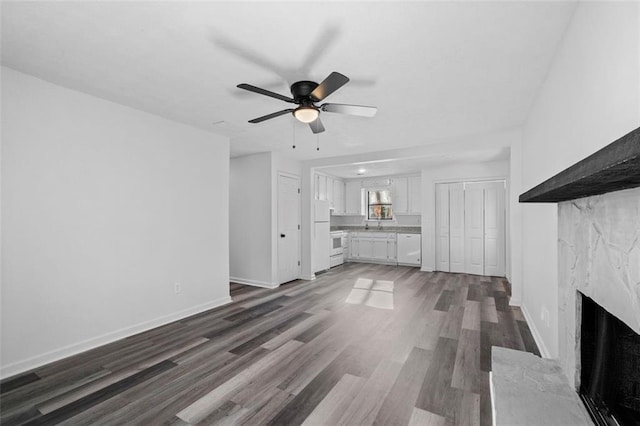 2571 Hamill Dr, Buford, GA 30519 - unfurnished living room featuring a premium fireplace, dark wood finished floors, ceiling fan, and baseboards