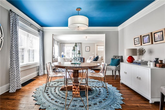 dining room with visible vents, wood finished floors, baseboards, and ornamental molding