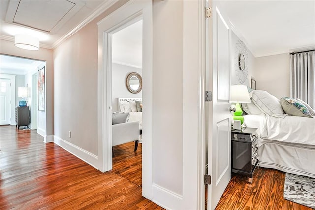 hallway with wood finished floors, baseboards, and ornamental molding